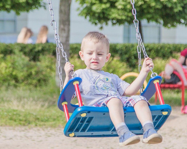 Ребенок на детской площадке перед волейбольным центром в Одинцово, Август