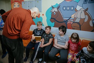 Партиец передает книгу для «Доброй комнаты»