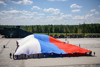 Волонтёры раздавали ленты, флажки, а также развернули многометровое полотно с изображением российского флага