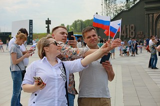 Волонтёры раздавали ленты, флажки, а также развернули многометровое полотно с изображением российского флага